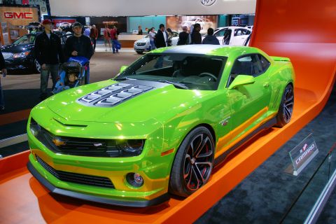 1993 Ford Taurus - A bright green Chevrolet Camaro is displayed at an auto show.