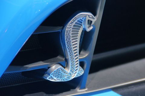 1993 Ford Taurus - Close-up of a silver Cobra emblem on the fender vent of a blue vehicle.