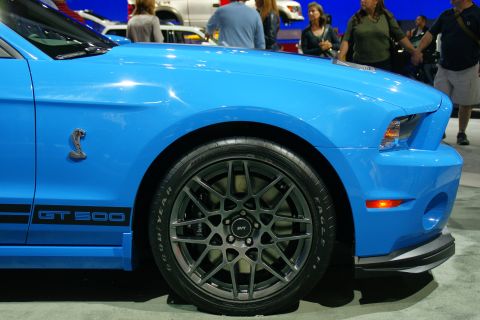 1993 Ford Taurus - Close-up of a blue Ford Mustang GT500 showing the front fender, wheel, and side stripe.