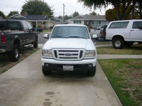 1988 Ford Bronco - A white Ford Ranger pickup truck is parked in a driveway with other vehicles.