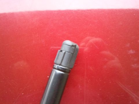 1998 Ford Crown Victoria - A close-up view of a hood strut mount against a red background, with a website watermark at the bottom.
