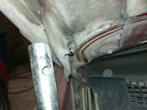 1998 Ford Crown Victoria - Close-up view of a hood latch mechanism, possibly being worked on with a tool.
