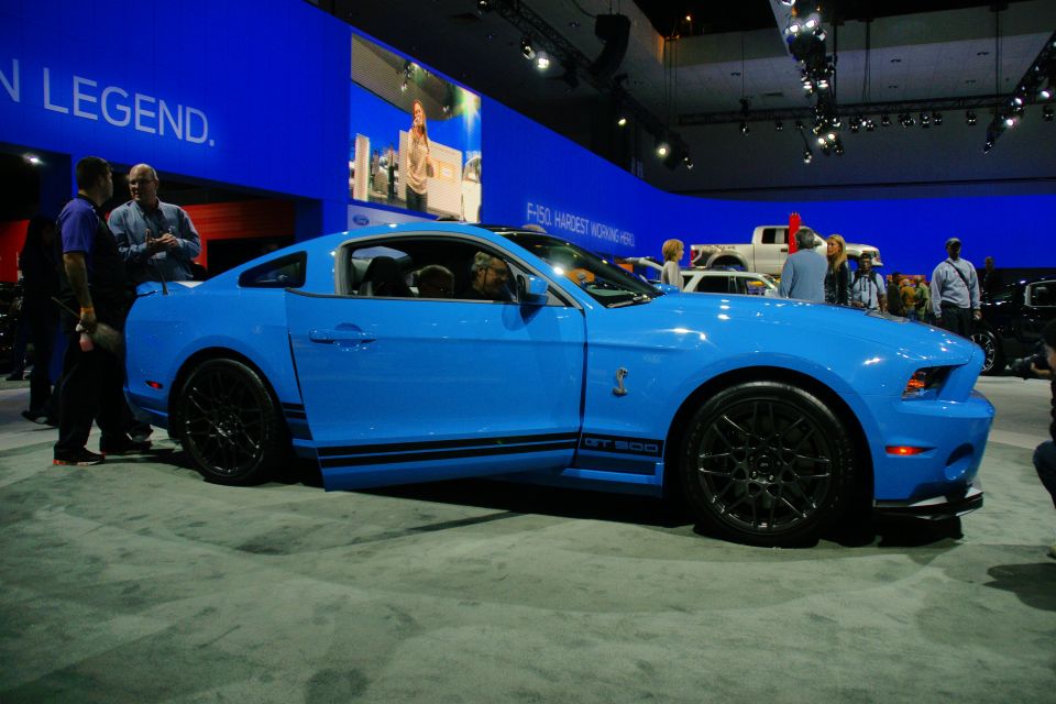 Blue Ford Mustang GT500 with black racing stripes and wheels