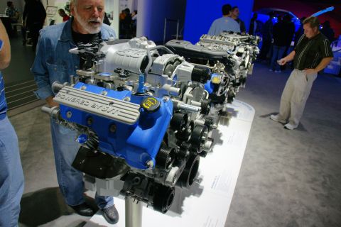 1993 Ford Taurus - A blue engine with "POWERED BY SVT" visible is displayed at an auto show.
