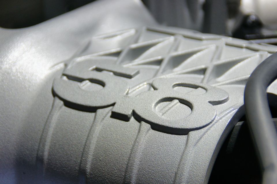 Close-up of a silver engine intake manifold with "5.8" cast into it