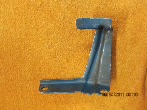 1969 Ford Mustang - Metal bracket with blue paint and two mounting holes, photographed on a textured surface.