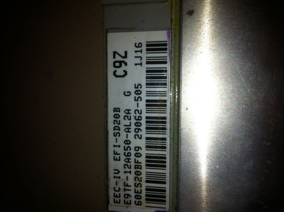 Close-up of an engine control unit label with part numbers and a barcode