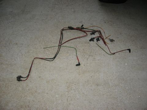 1994 Ford Bronco - A collection of wires and connectors, likely a vehicle wiring harness, lies on a concrete floor.