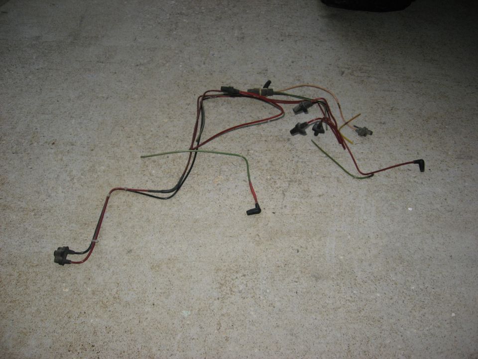 Wiring harness with multiple connectors and colored wires laid out on a concrete surface