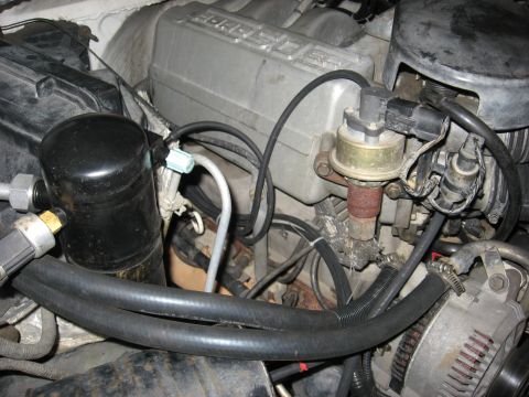 1994 Ford Bronco - Close-up view of engine components including vacuum lines, AC accumulator, and distributor.