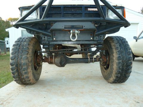 1992 Ford Mustang - The front axle and suspension of a modified Toyota truck are visible, with a custom bumper and winch mounted.