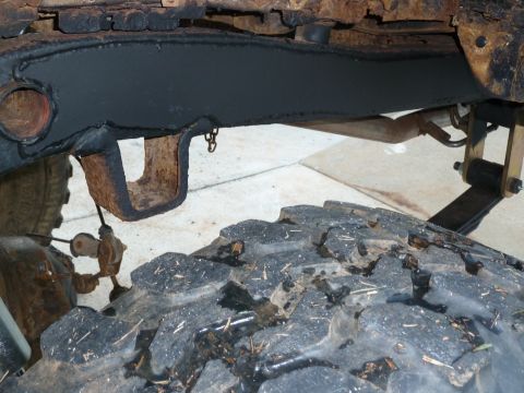 1992 Ford Mustang - Detail of a heavily corroded vehicle frame and a large, treaded tire, showing signs of wear and tear.