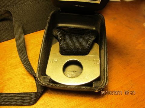 1969 Ford Mustang - A close-up view of a seatbelt buckle, showing stamped markings and its internal mechanism.
