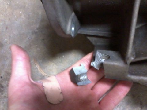 1985 Ford Bronco - Broken bolt and nut being held in a hand with band-aids.