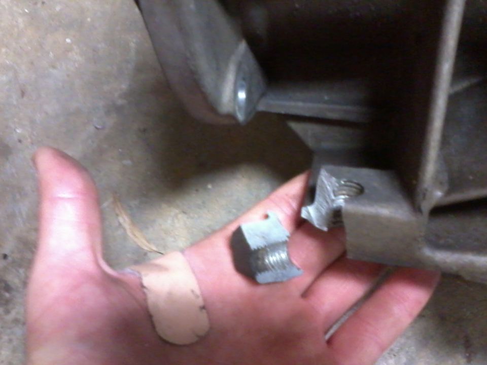 Hand with band-aids holding a broken bolt and nut