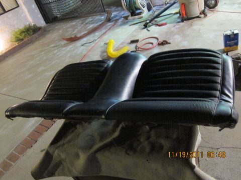 1969 Ford Mustang - A black vinyl car seat with ribbed upholstery is shown resting on a tarp.