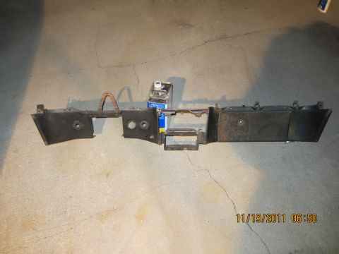 1969 Ford Mustang - A detached car dashboard section is shown on a concrete surface, with a bottle of liquid nearby.