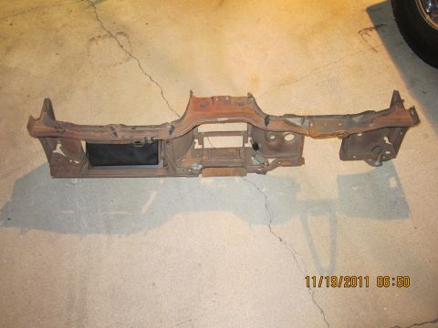 1969 Ford Mustang - This is a rusted metal dashboard frame, likely from an older vehicle, shown lying on a concrete surface.