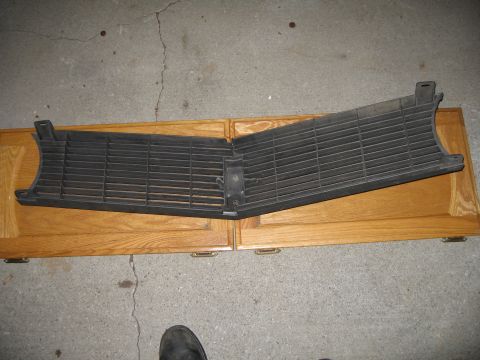 1969 Ford Mustang - A car's front grille is shown lying flat on top of two wooden cabinets.