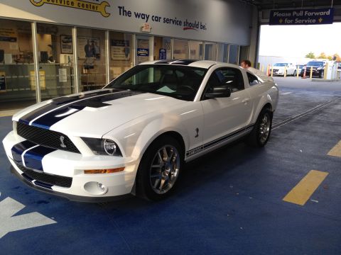 2007 Ford Mustang - This white 2007 Ford Mustang GT500 features iconic blue racing stripes and is seen in a service center.