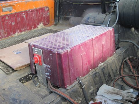 1978 Ford Bronco - An auxiliary fuel tank is installed in the rear of the vehicle, secured with a metal bracket and a red cutoff switch.
