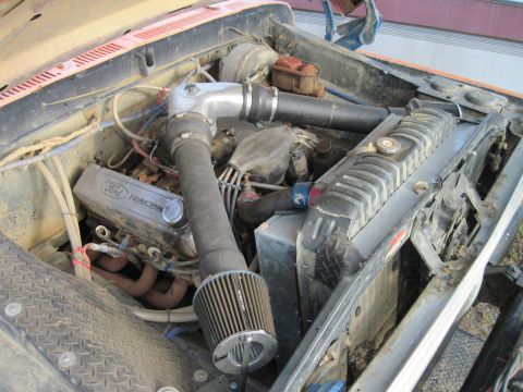 1978 Ford Bronco - The engine bay of a vehicle, a Ford Racing valve cover and an aftermarket air intake system.