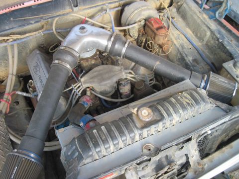1978 Ford Bronco - The engine bay features a V8 engine with a custom intake and air filters, along with a visible Ford Racing sticker.