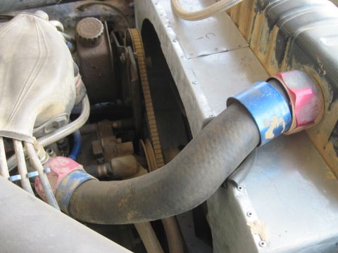 1978 Ford Bronco - Close-up view of a radiator hose and engine components within a vehicle's engine bay.