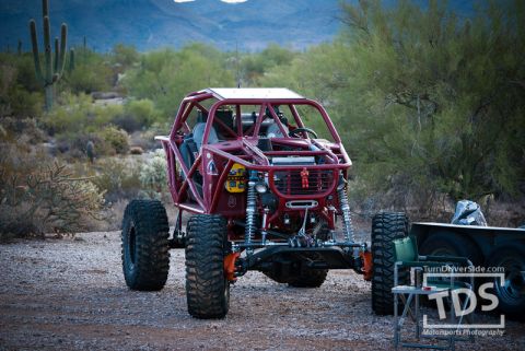 Suzuki Samurai - A custom-built off-road buggy with a prominent roll cage is parked in a desert environment.