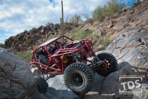 Suzuki Samurai - Custom rock crawler navigating a rocky desert trail with saguaro cacti in the background.