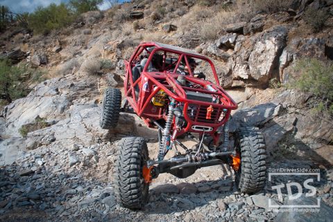 Suzuki Samurai - A custom-built off-road buggy navigates a steep, rocky incline.