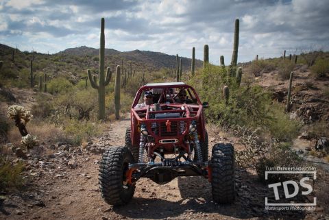 Suzuki Samurai - A custom-built off-road buggy navigates a desert trail under a cloudy sky.