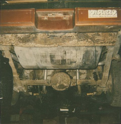 1978 Pontiac Trans Am - The underside of a vehicle shows the rear axle, fuel tank, and exhaust system, with a sticker on the bumper.