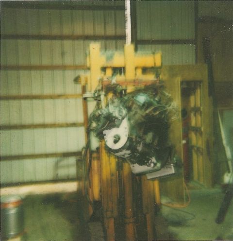 1978 Pontiac Trans Am - Engine block suspended by yellow machinery in a workshop.