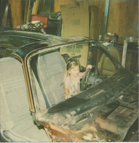 1978 Pontiac Trans Am - A young girl pretends to drive a car while sitting in the driver's seat.