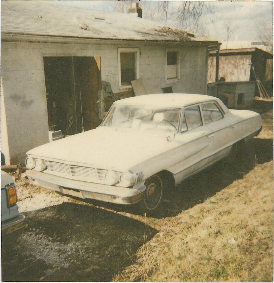 White 1963 Ford Galaxie 500 sedan parked in front of a garage