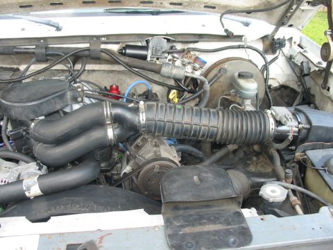 1992 Ford Bronco - Close-up view of an engine bay, focusing on the mass air flow sensor and associated intake components.