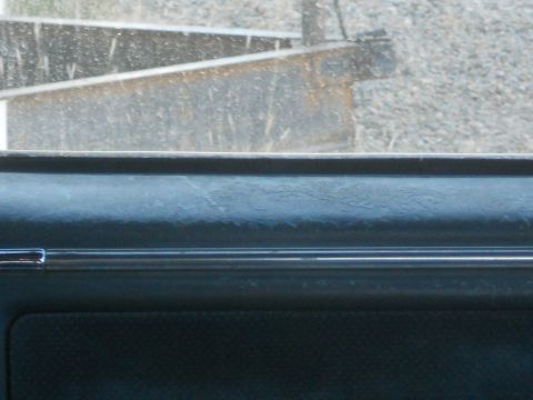 1986 Ford Bronco - Close-up of dark interior dashboard trim with a horizontal chrome accent.