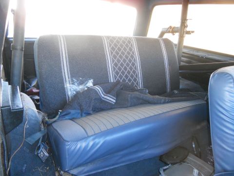 1986 Ford Bronco - Interior view of a vehicle's rear bench seat, showing upholstery details and a roll bar.
