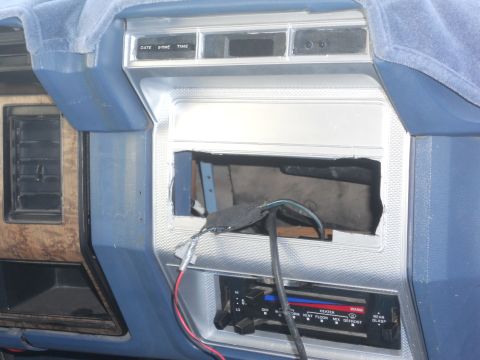 1986 Ford Bronco - The dashboard of a 1986 Ford Bronco shows an open radio slot with wires exposed, and climate controls below.