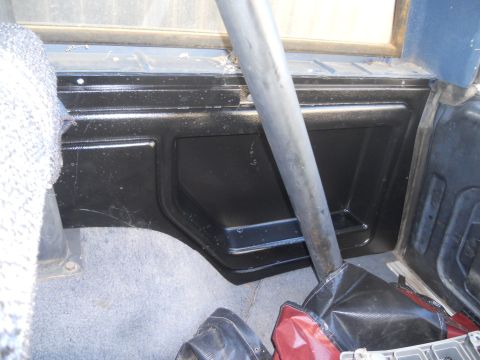 1986 Ford Bronco - Close-up view of the interior of a vehicle, showing a black panel and a metal roll bar.