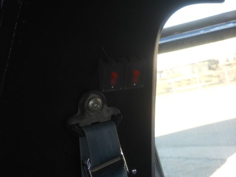 1986 Ford Bronco - A close-up shot reveals two illuminated red switches and a seatbelt within the vehicle's interior.