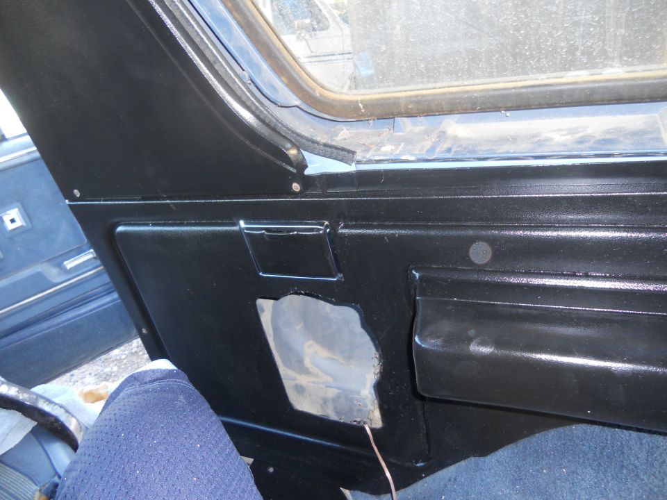 Black interior door panel with a cutout revealing insulation