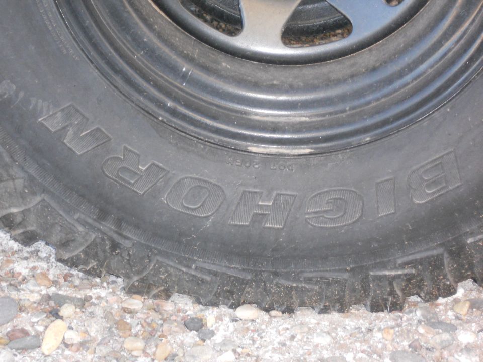 BFGoodrich All-Terrain T/A tire with 'BIG HORN' text, on gravel