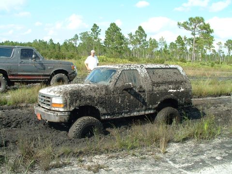 1995 Ford Bronco - Two Ford Broncos are stuck in the mud during an off-road event.