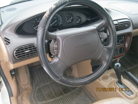1984 Chevrolet C/K Pickup - The interior of a car is visible, showing the steering wheel, dashboard, and center console.