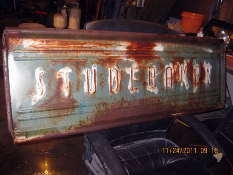 1984 Chevrolet C/K Pickup - A heavily rusted Studebaker tailgate is shown, with visible teal and red paint layers.