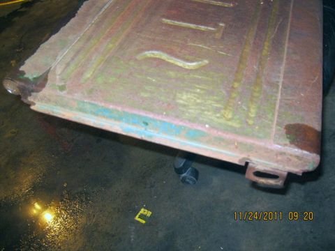 1984 Chevrolet C/K Pickup - Close-up of a rusted metal panel with embossed lines and remnants of blue paint.
