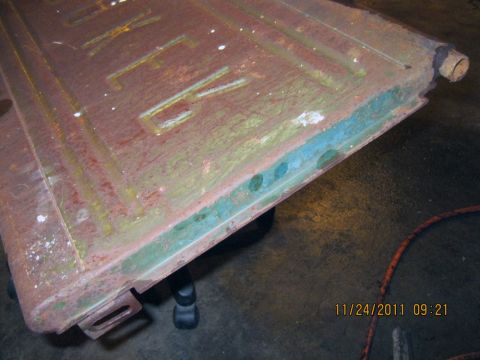 1984 Chevrolet C/K Pickup - A close-up view of a weathered metal panel, possibly a truck tailgate, with embossed lettering.