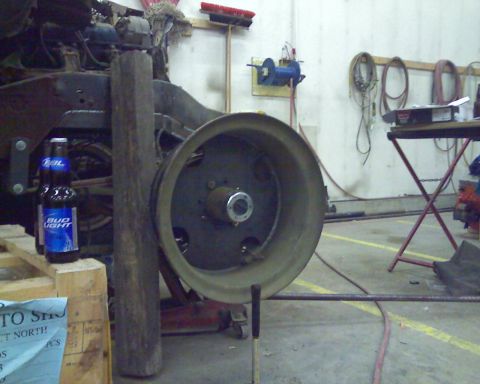 1978 Chevrolet C/K Pickup - A large wheel hub assembly is shown in a workshop setting, with a bottle of Bud Light nearby.